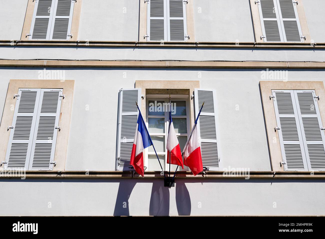 Bandiera rossa bianca francese blu sul municipio in francia edificio ufficiale in città Foto Stock
