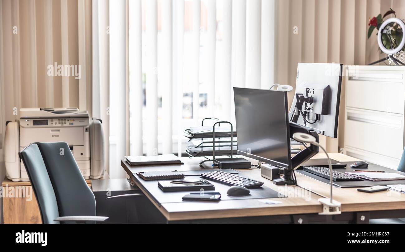 Ufficio vuoto dotato di computer, tablet, stampante e mobili per ufficio. Foto Stock
