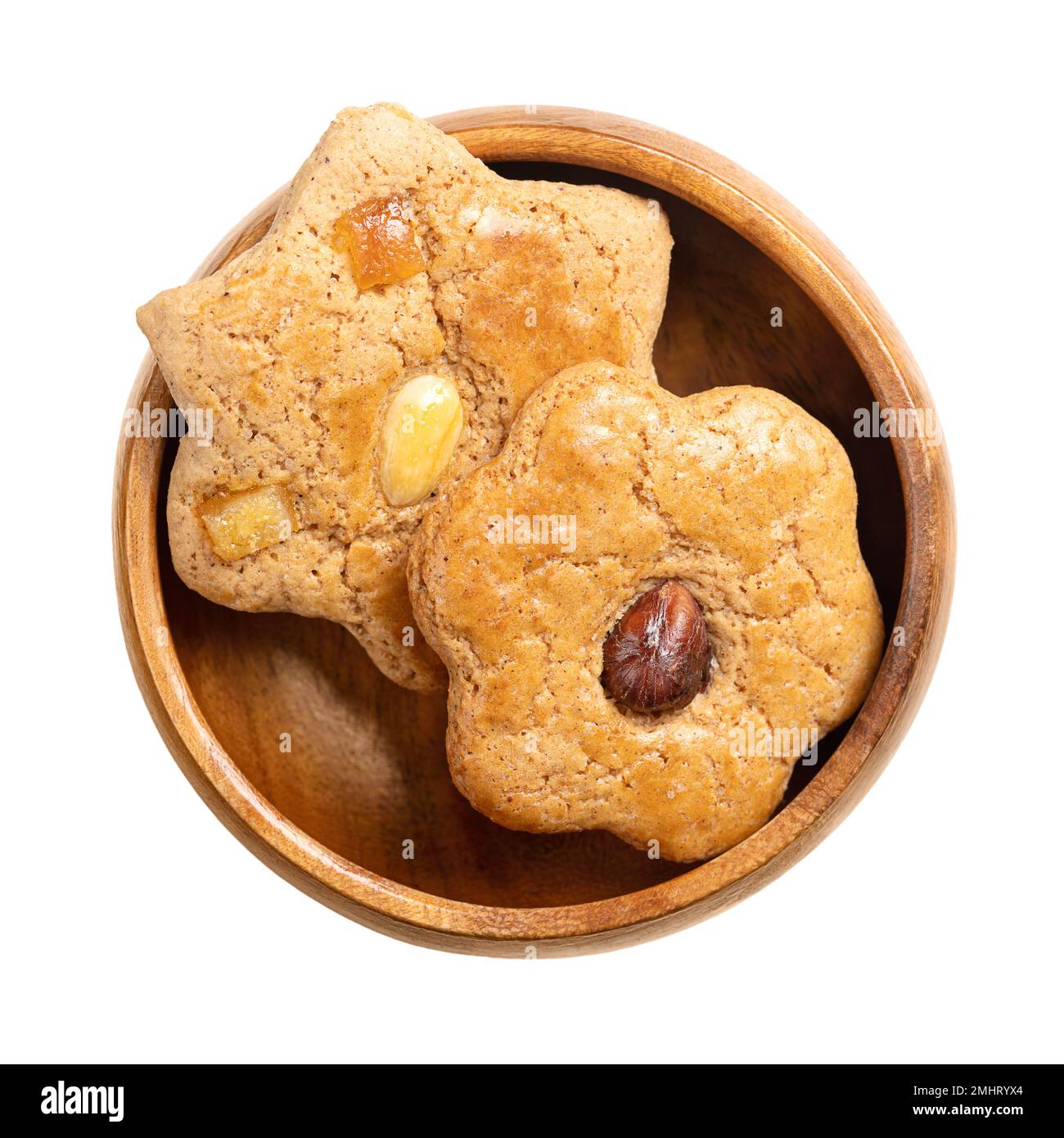 Biscotti di pan di zenzero fatti in casa, in una ciotola di legno. Prodotti da forno dolci, marroni, piatti e a forma di stella, con canditi e con metà noce sulla parte superiore. Foto Stock