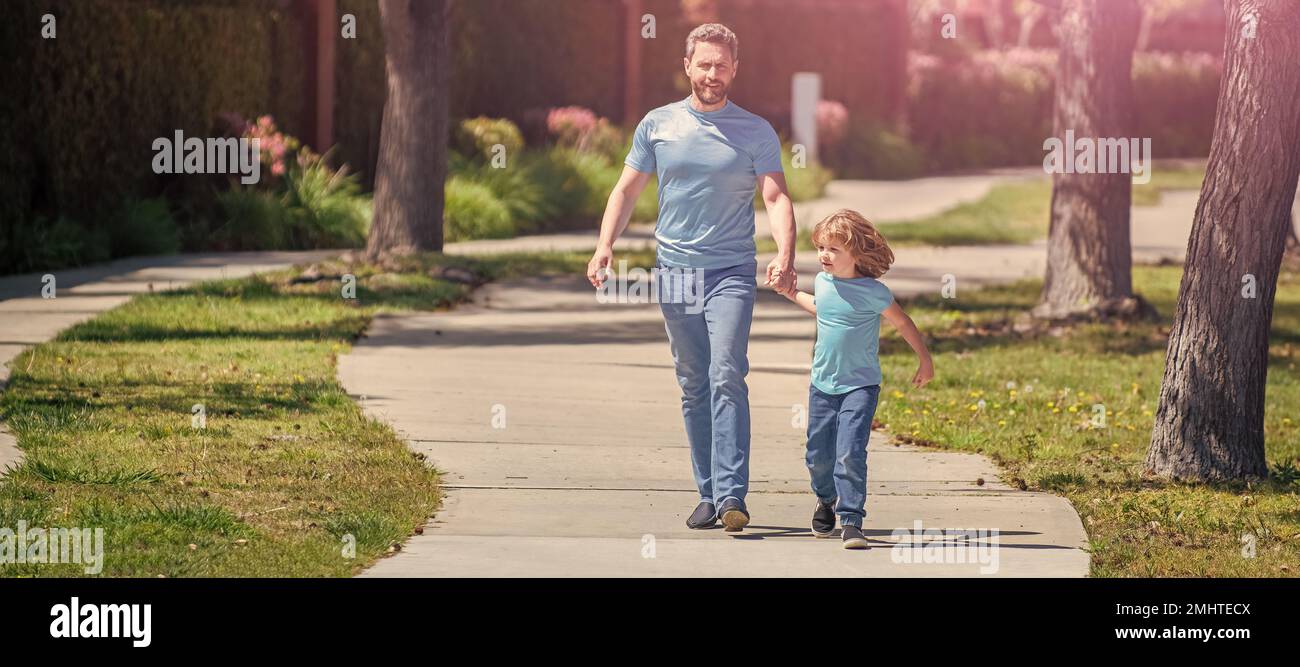 Banner di padre e figlio a piedi, allegro papà con bambino rilassarsi insieme nel parco, famiglia a piedi Foto Stock