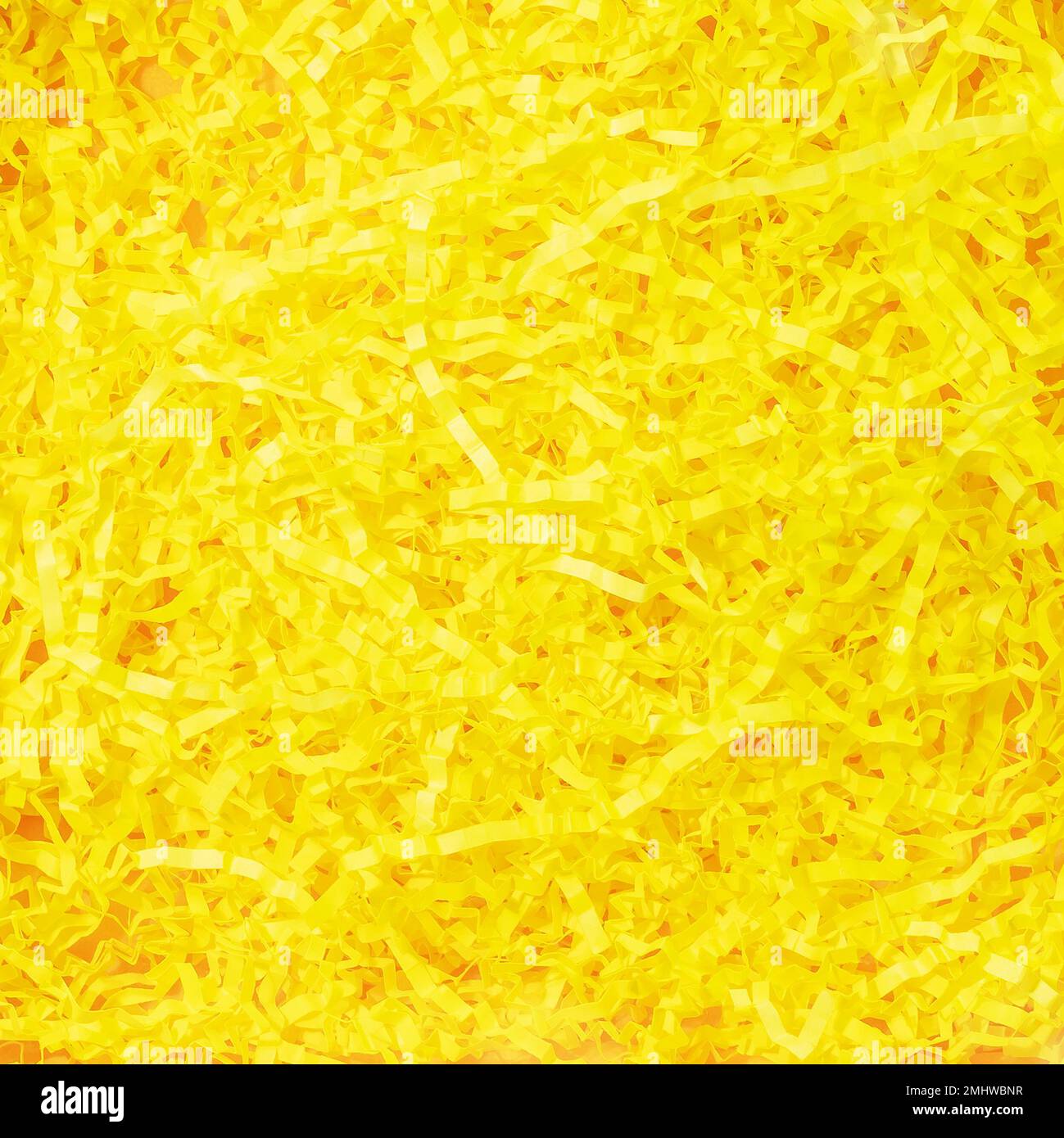 Grana del riempitivo di carta giallo. Materiale di imballaggio della carta triturato. Spaghetti gialli soleggiati carta da imballaggio usata per proteggere gli oggetti fragili mentre sono dentro Foto Stock