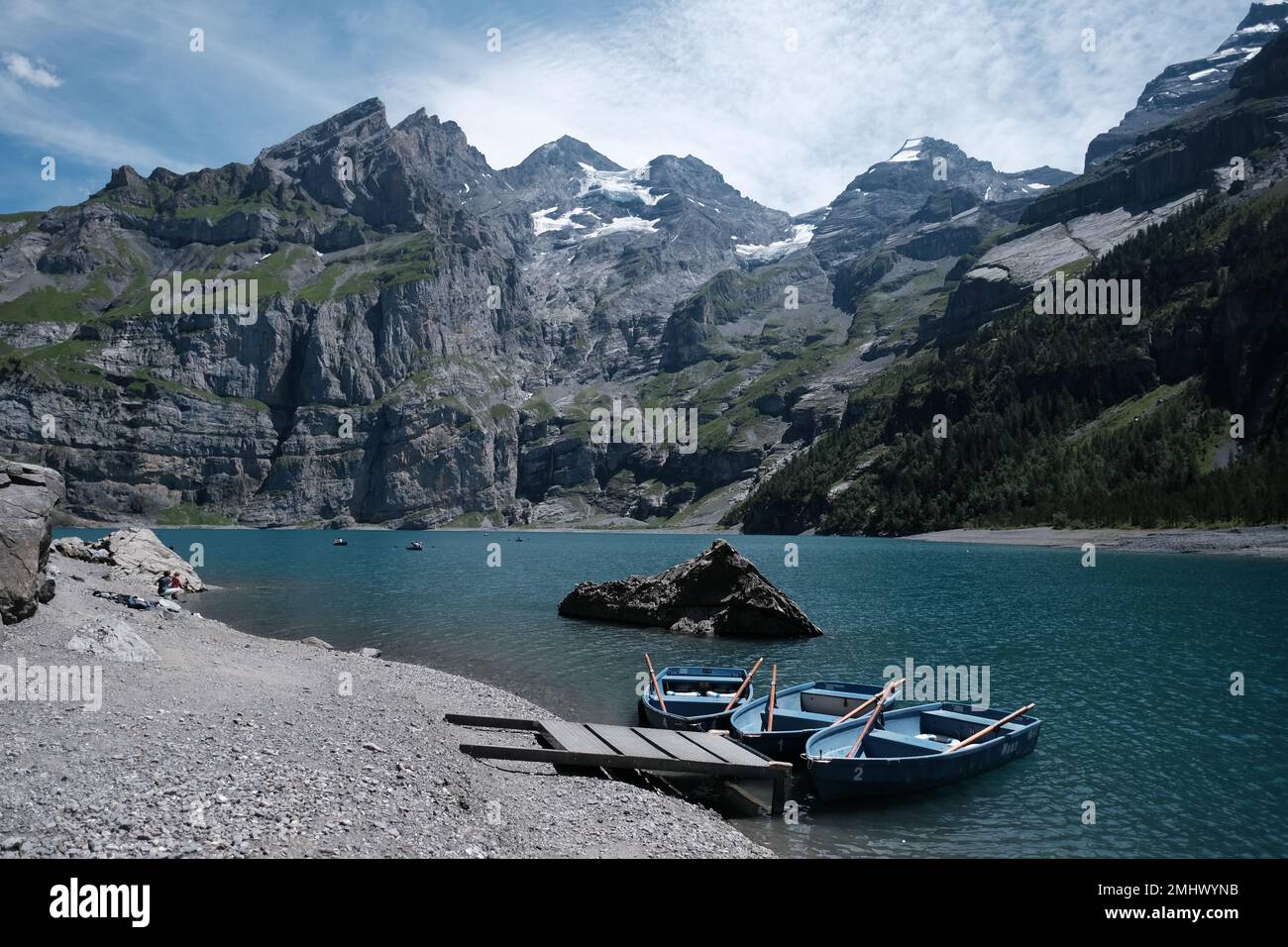Una bella foto di kayak blu su una costa del lago circondata da colline rocciose Foto Stock