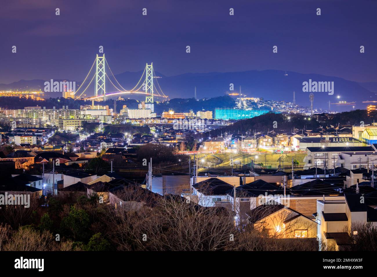 Suspension Bridge Torri su Case in quartiere residenziale di notte Foto Stock