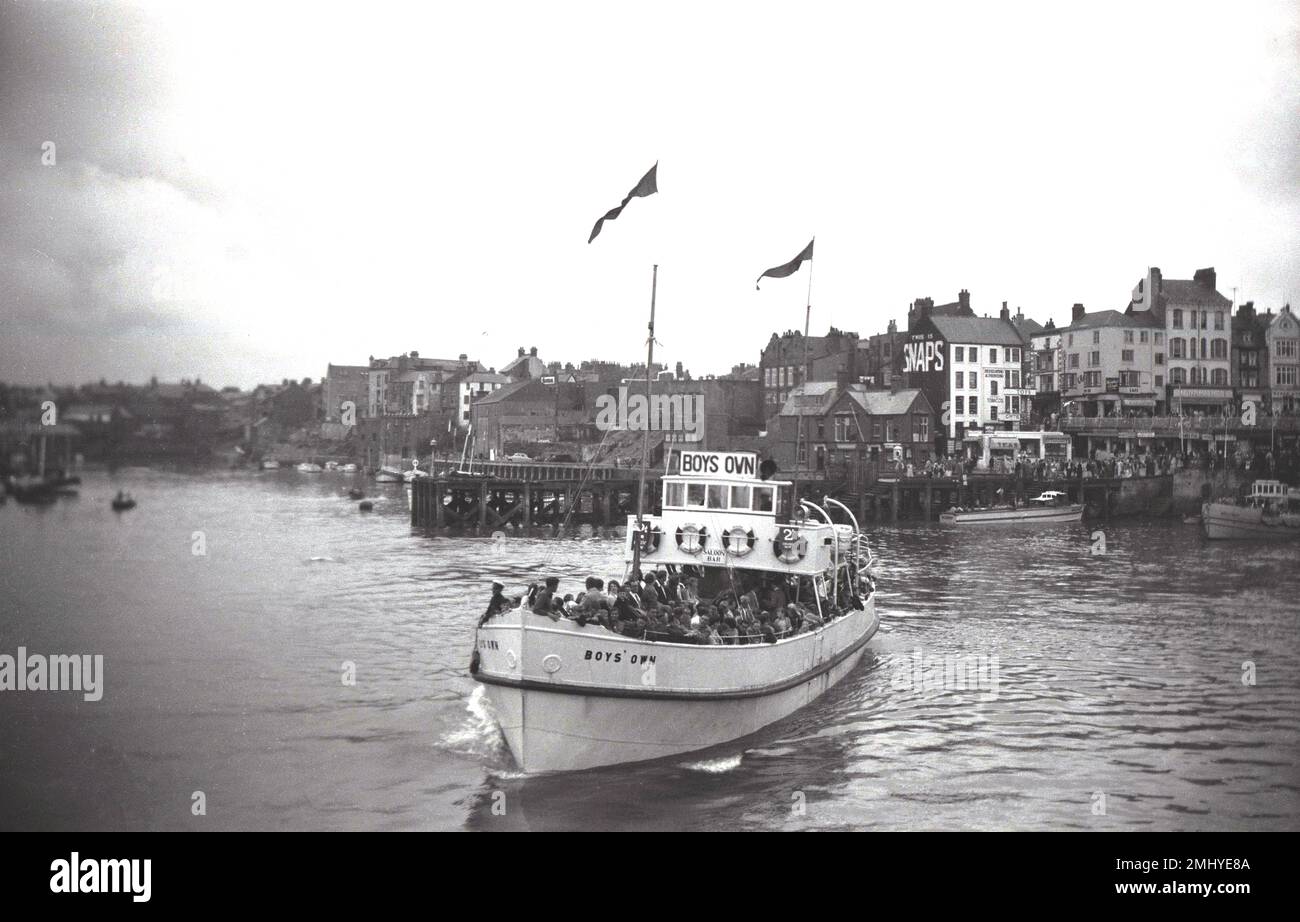 1950, storico, pieno di passeggeri, la barca da diporto, 'Boys own' lasciando il porto di Bridlington, East Yorkshire, Inghilterra, Regno Unito. Costruito nel 1938, 'Boys Own' era una delle cinque navi da escursione che lavoravano a Bridlington in quest'epoca, conosciuta come 'le Belles del Mare del Nord'. Foto Stock