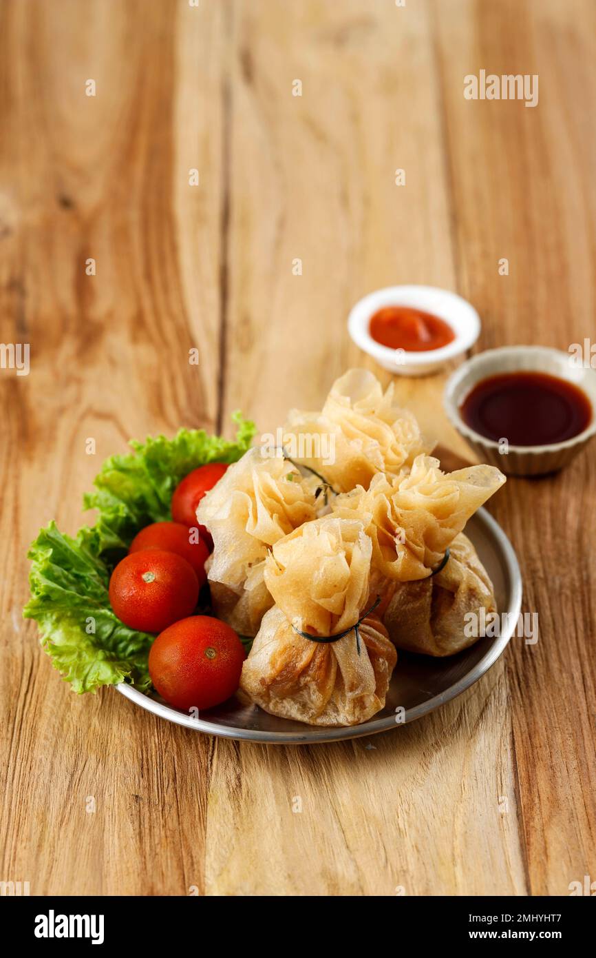 Wonton, Oriental Deep Fried Wontons ripieno di gamberi e cipolla primaverile, servito con salsa di soia e peperoncino. Foto Stock