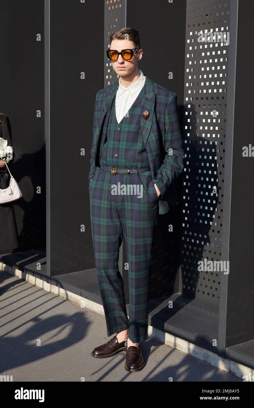 MILANO, ITALIA - 13 GENNAIO 2023: Uomo con giacca e pantaloni a scacchi verdi e blu prima della sfilata Gucci, Milano Fashion Week Street Style Foto Stock