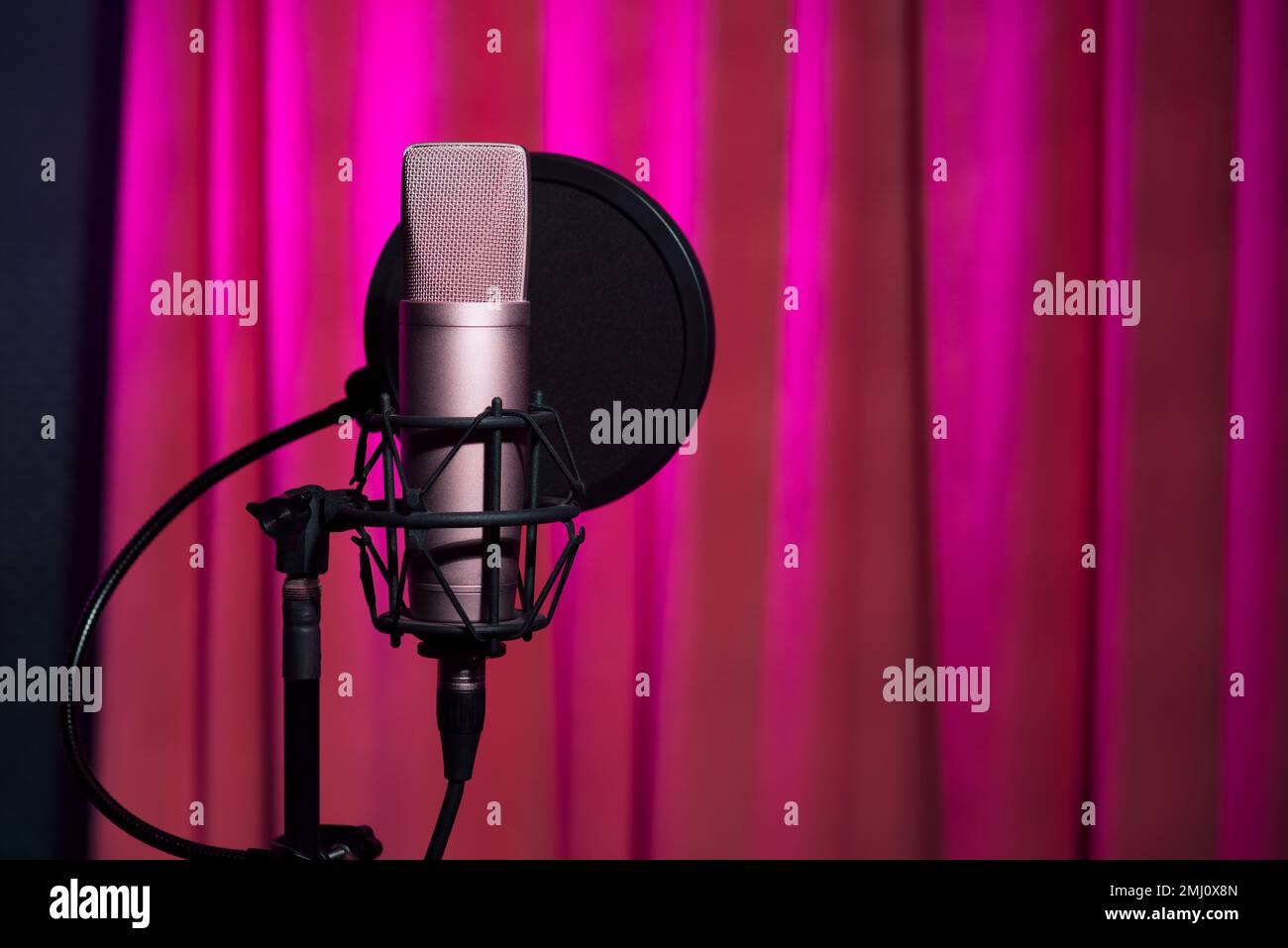 Microfono a condensatore con isolamento acustico in Studio di registrazione Shadow Silhouette in Purple Neon Light background, primo piano Foto Stock