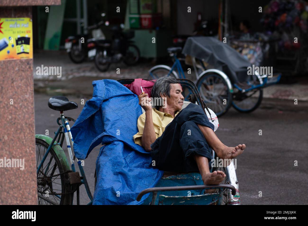 Uomo fumo sigaretta - Chung cư B Chợ Đầm - Vietnam blocchi di appartamenti intorno al mercato Dam ( Chợ Đầm ) Nha Trang Vietnam Foto Stock