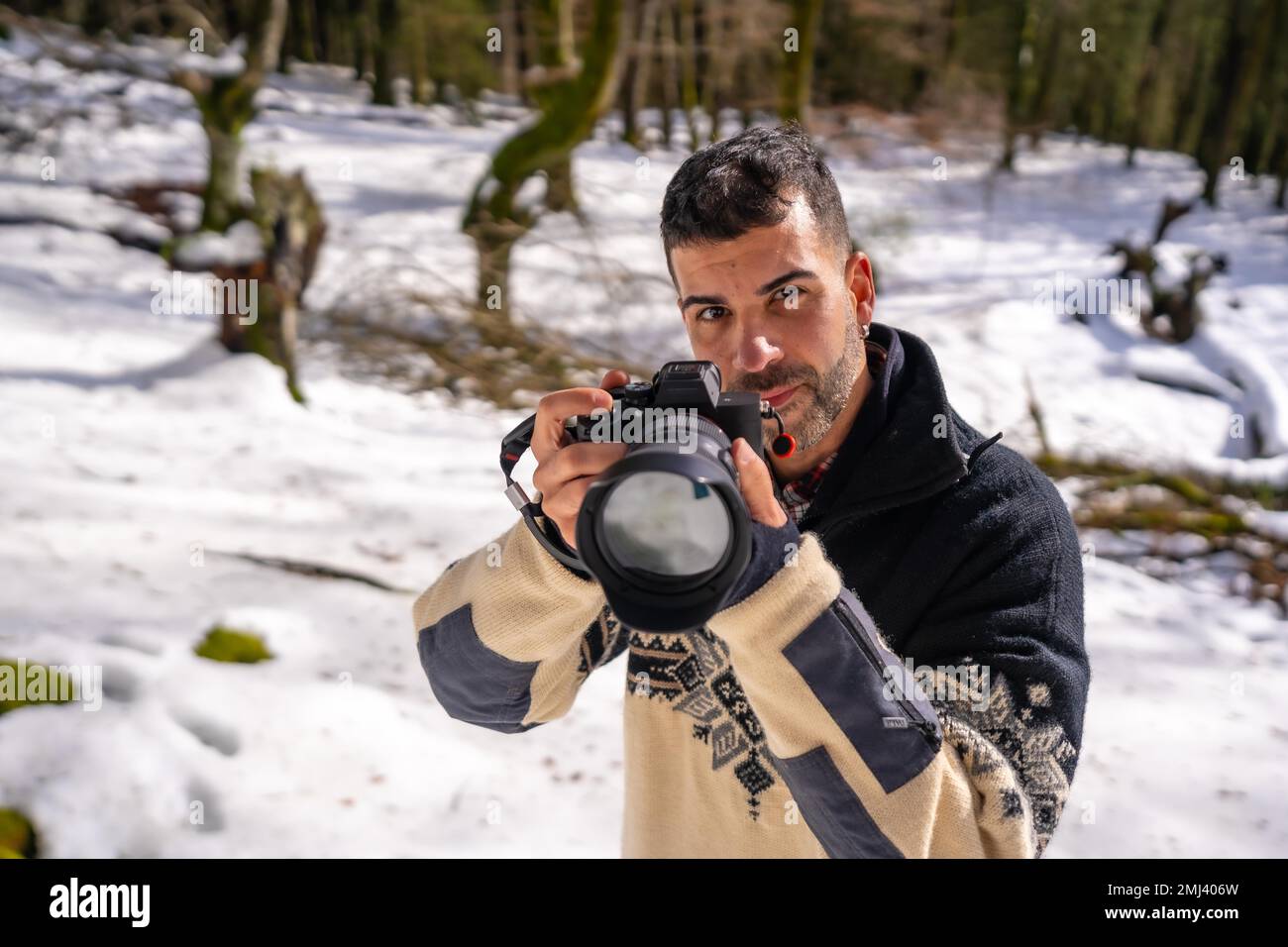 Fotografo che scatta una foto sulla neve e che si diverte a fotografare in inverno in una foresta innevata Foto Stock