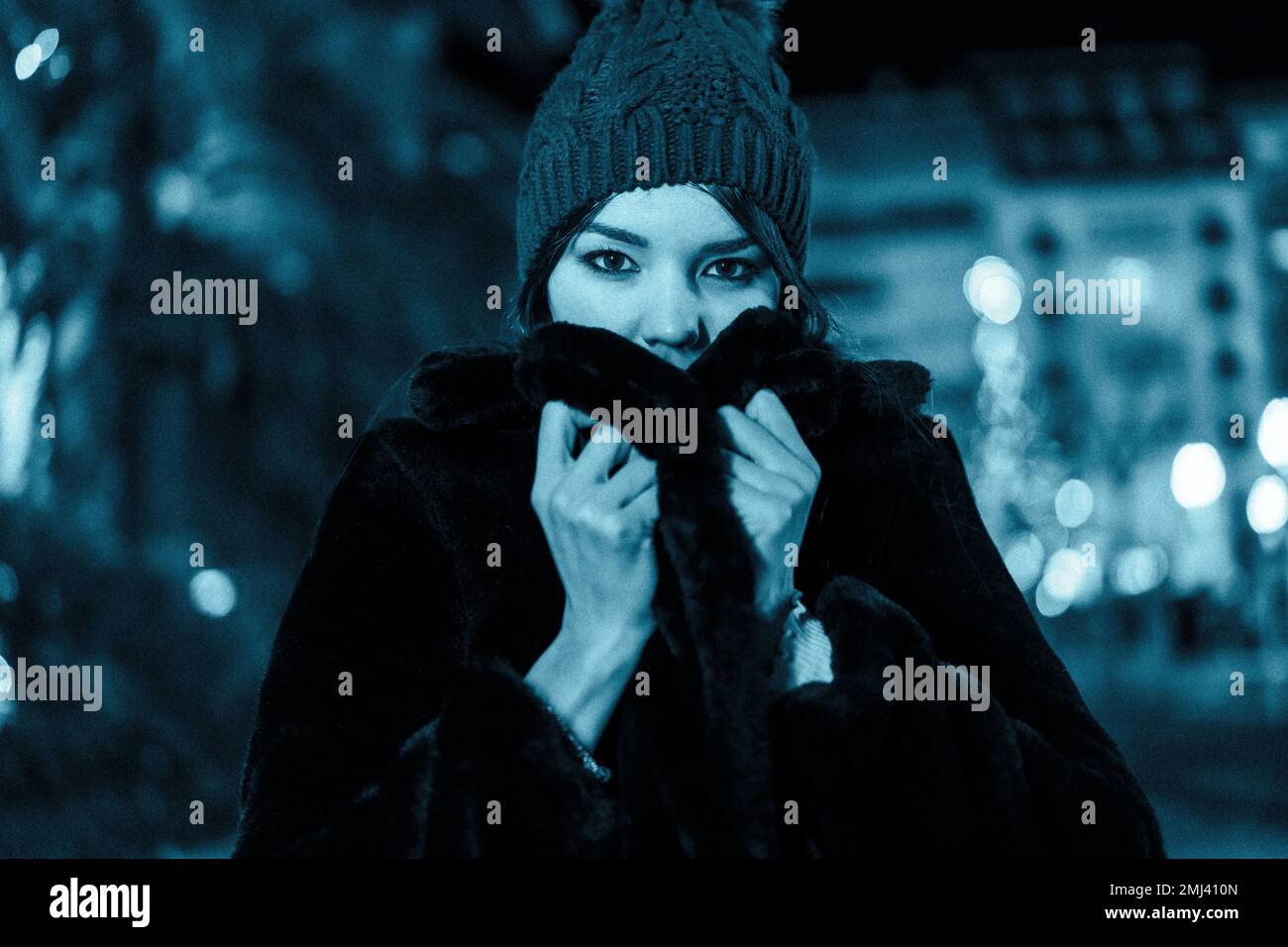 Natale in città, inverno, decorazione. Fredda notte invernale a natale con cappello e sciarpa Foto Stock