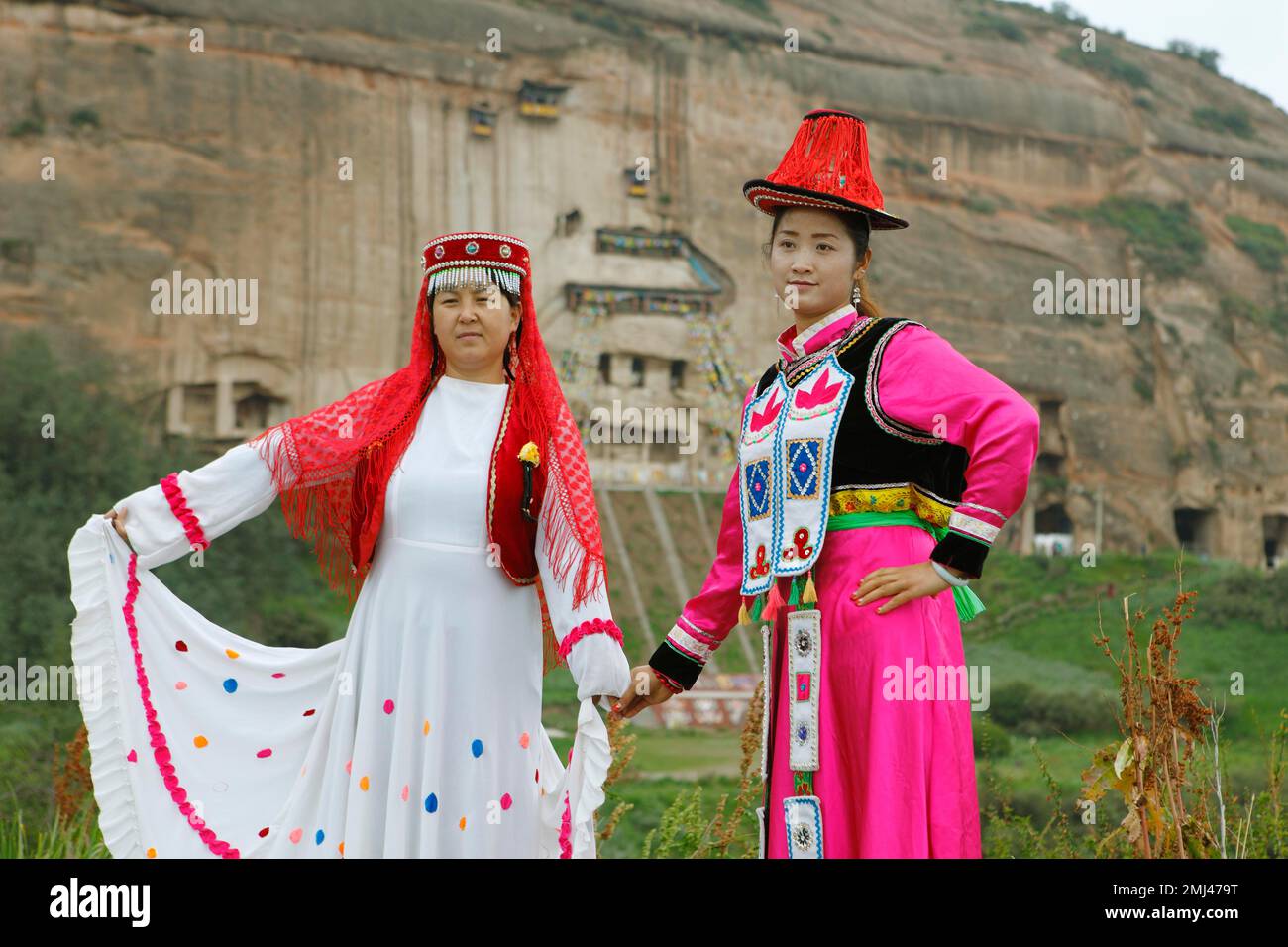 I visitatori cinesi posano in costumi tradizionali presi in prestito presso le grotte rocciose del Monastero Mati, Zhangye, Provincia di Gansu, Cina Foto Stock