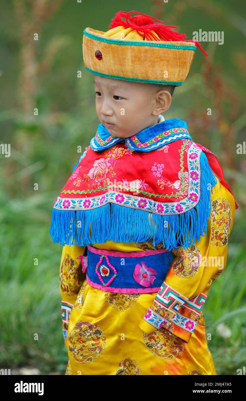 Piccolo ragazzo in costume tradizionale, Zhangye, Provincia di Gansu, Cina Foto Stock