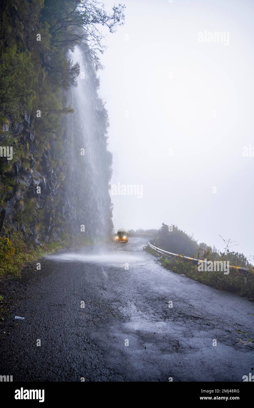 Cascata dos Anjos, autobus VW conduce attraverso una cascata sulla strada, Madeira, Portogallo Foto Stock