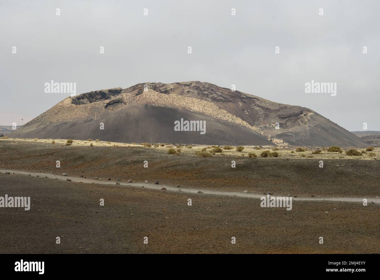 Vecchio cono vulcanico circondato da lava a Tinajo, Lanzarote Foto Stock