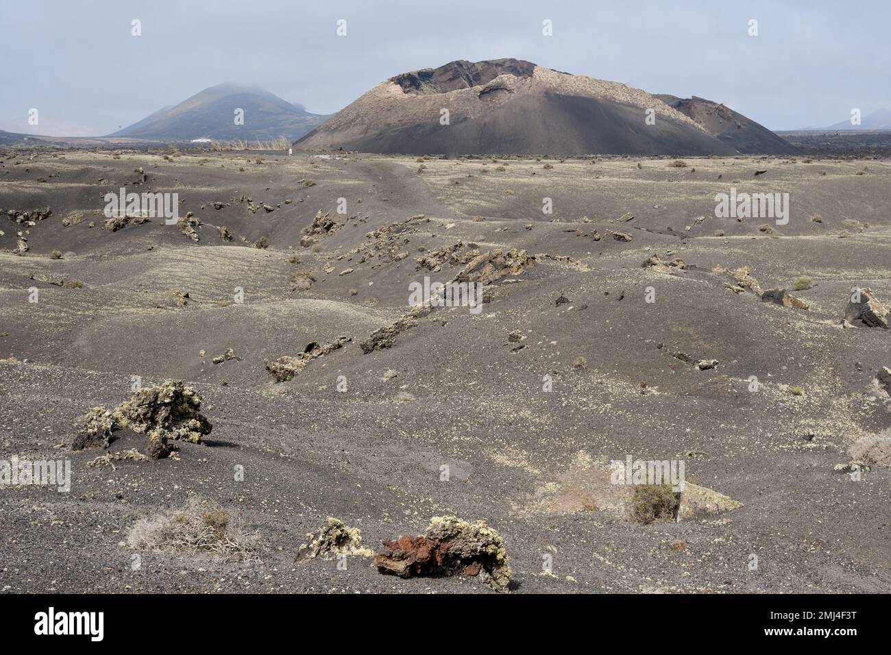 Vecchio cono vulcanico circondato da lava a Tinajo, Lanzarote Foto Stock