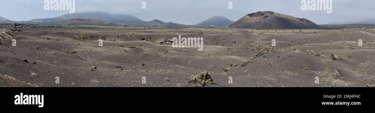Vecchio cono vulcanico circondato da lava a Tinajo, Lanzarote Foto Stock