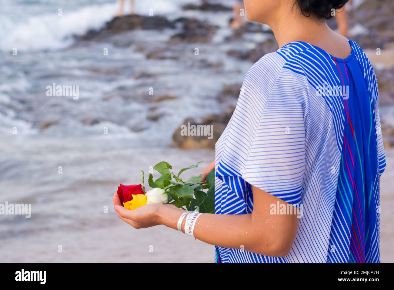 Salvador, Bahia, Brasile - 02 febbraio 2017: Una donna che ammira Candomble getta fiori in mare in onore di Iemanja il giorno della sua festa. Salvador, Foto Stock