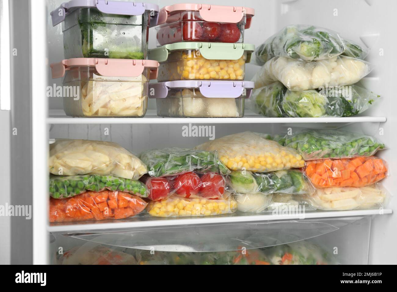 Sacchetti di plastica e contenitori con diverse verdure congelate in  frigorifero Foto stock - Alamy