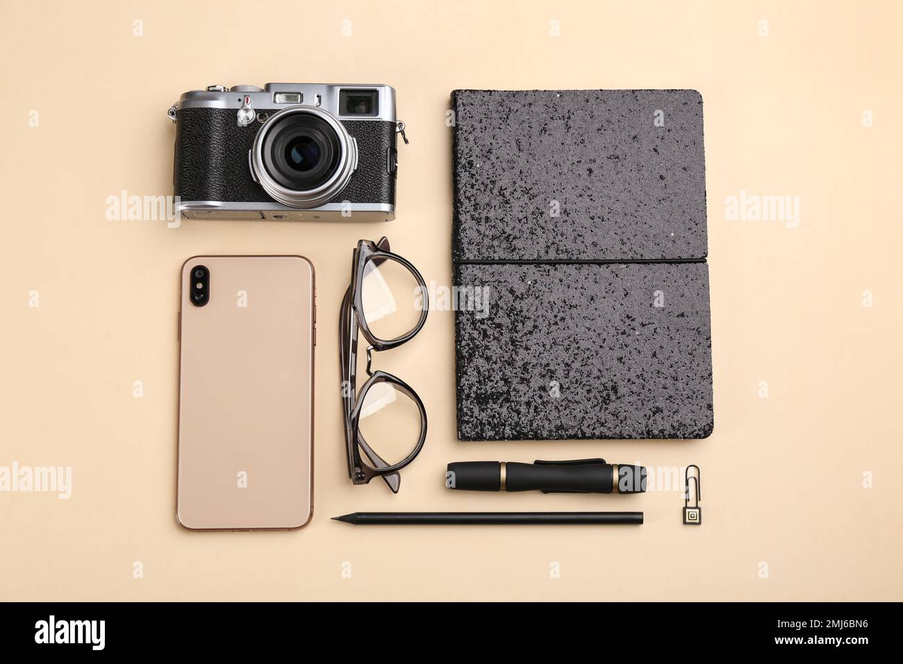 Composizione piatta con fotocamera per fotografo professionista, smartphone  e accessori su sfondo beige Foto stock - Alamy