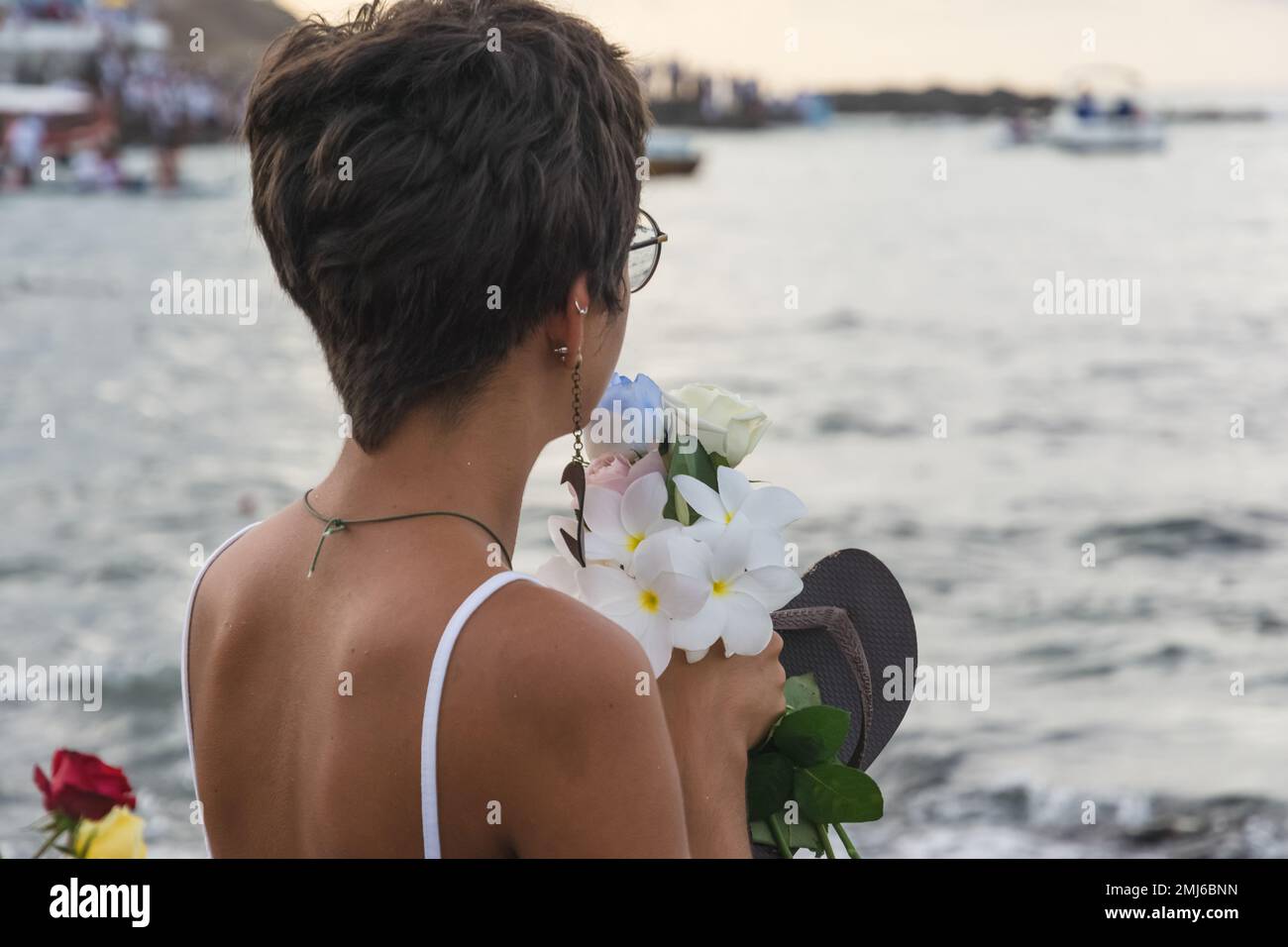 Salvador, Bahia, Brasile - 02 febbraio 2017: Una donna che ammira Candomble getta fiori in mare in onore di Iemanja il giorno della sua festa. Salvador, Foto Stock
