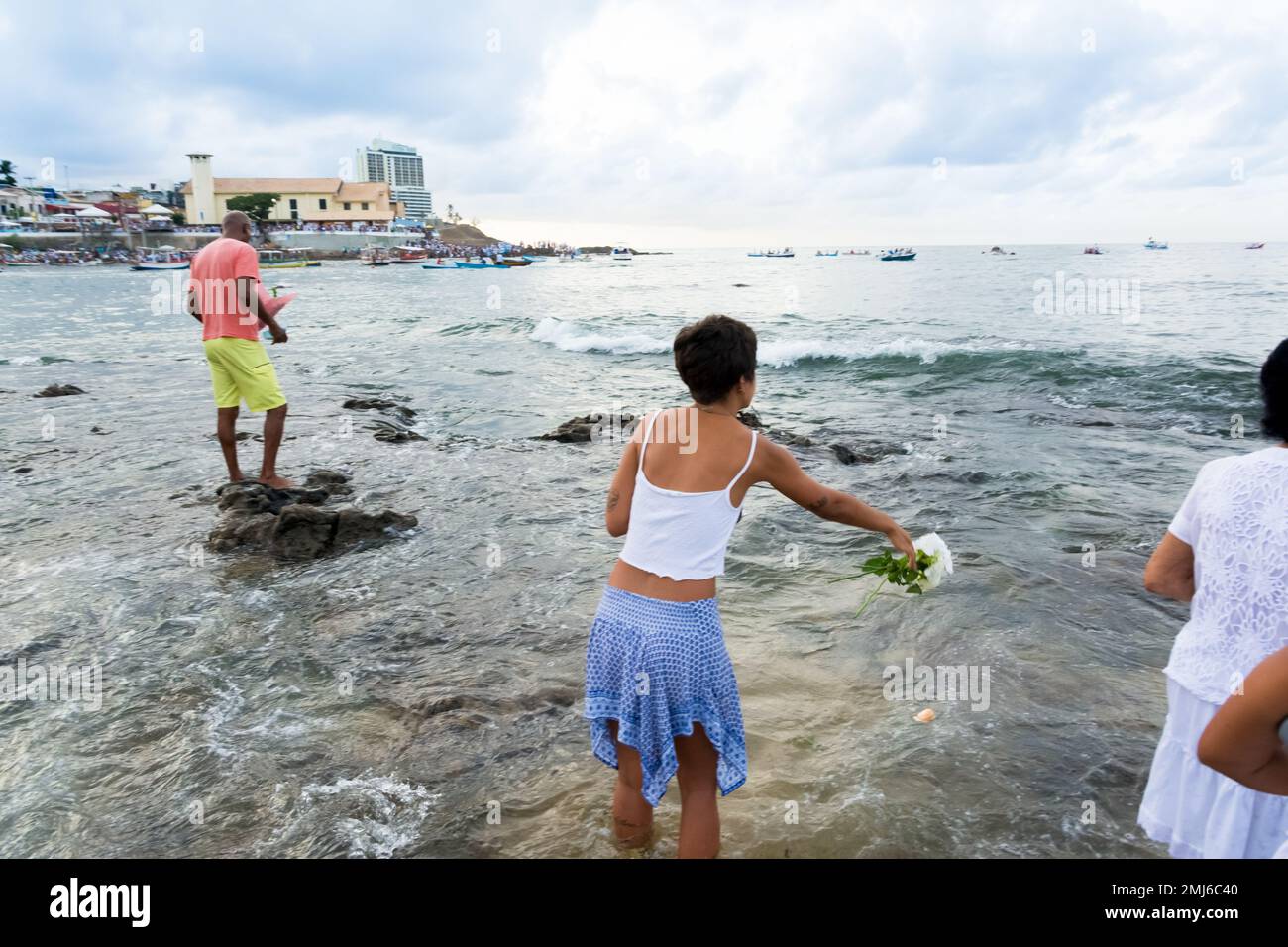 Salvador, Bahia, Brasile - 02 febbraio 2017: Una donna che ammira Candomble getta fiori in mare in onore di Iemanja il giorno della sua festa. Salvador, Foto Stock