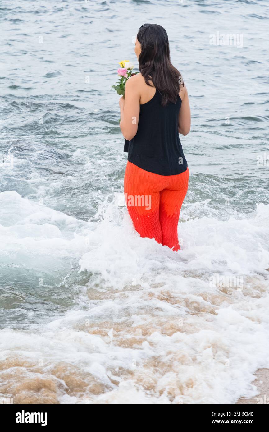 Salvador, Bahia, Brasile - 02 febbraio 2017: Una donna che ammira Candomble getta fiori in mare in onore di Iemanja il giorno della sua festa. Salvador, Foto Stock