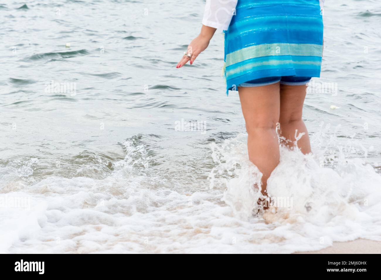 Salvador, Bahia, Brasile - 02 febbraio 2017: Una donna che ammira Candomble getta fiori in mare in onore di Iemanja il giorno della sua festa. Salvador, Foto Stock