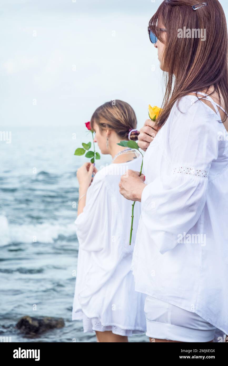 Salvador, Bahia, Brasile - 02 febbraio 2017: Una donna che ammira Candomble getta fiori in mare in onore di Iemanja il giorno della sua festa. Salvador, Foto Stock