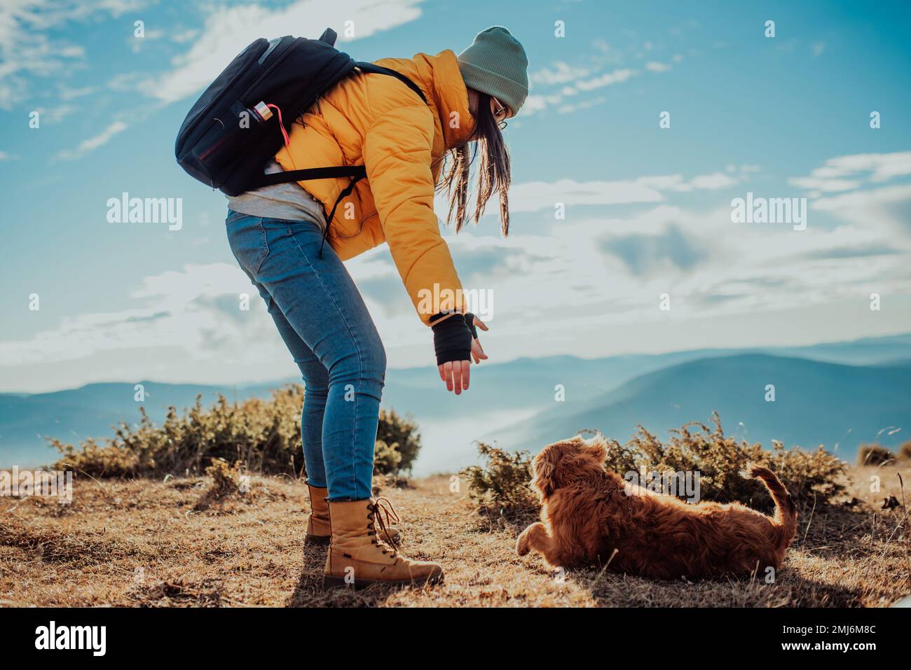 Ragazza con un cane giocare in montagna. Umore autunnale. Viaggiare con un PET.Woman e il suo cane in posa all'aperto. Foto Stock