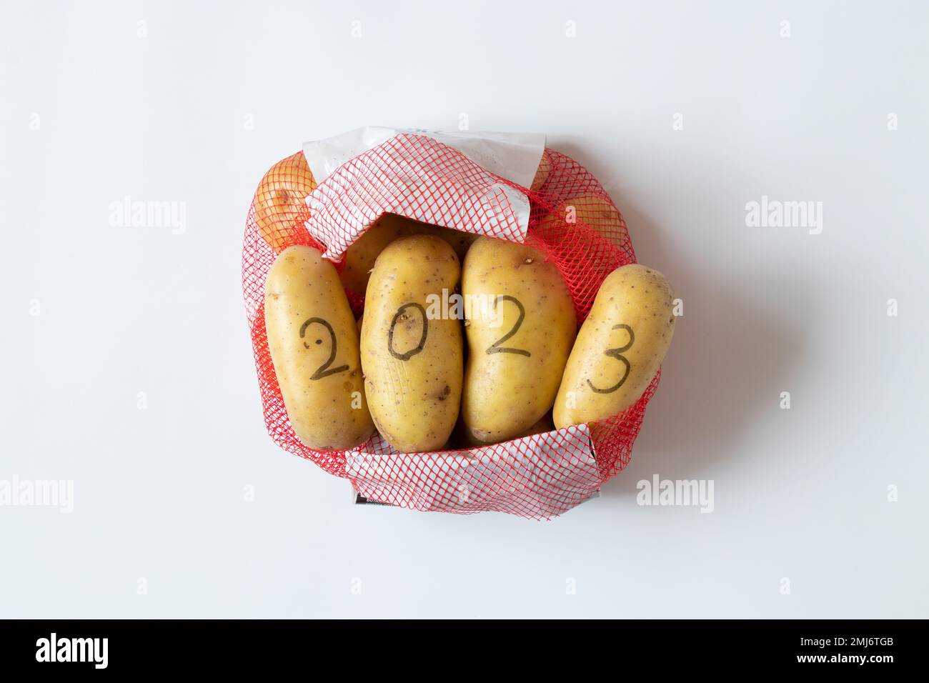 Patate nella griglia della drogheria con il numero 2023 scritto in matita nera, acquistare patate nel nuovo anno Foto Stock