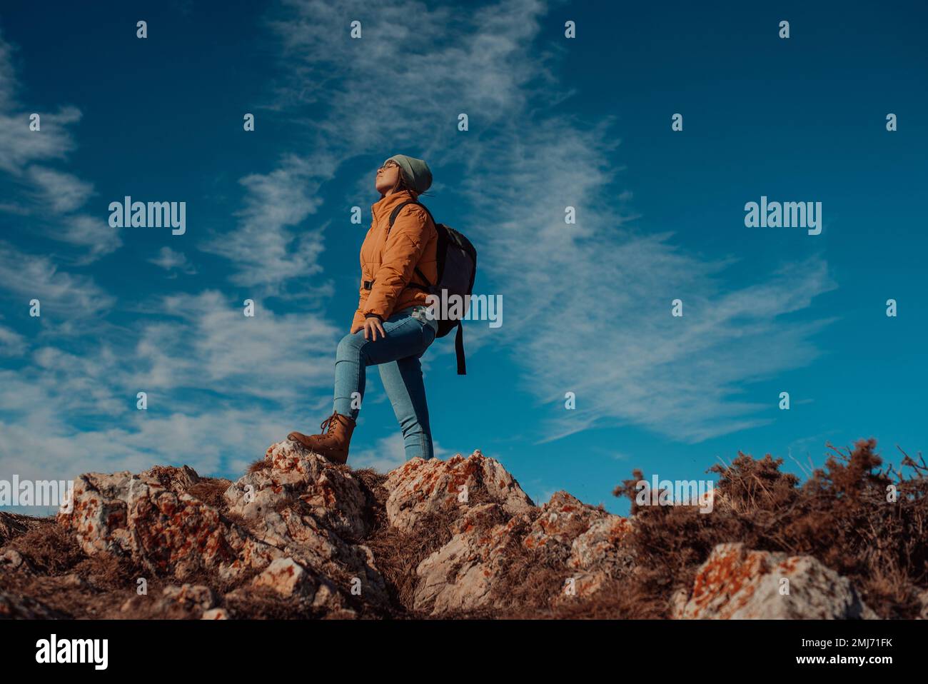 Allietare donna zaino in spalla godere della vista sul sunrise montagna bordo superiore scogliera Foto Stock