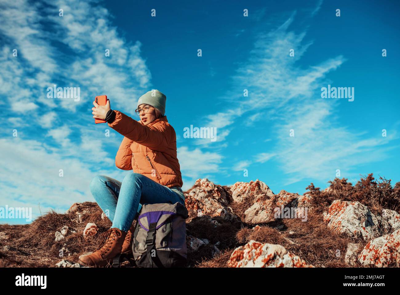 donna che prende un selfie con uno smartphone in cima a una montagna Foto Stock