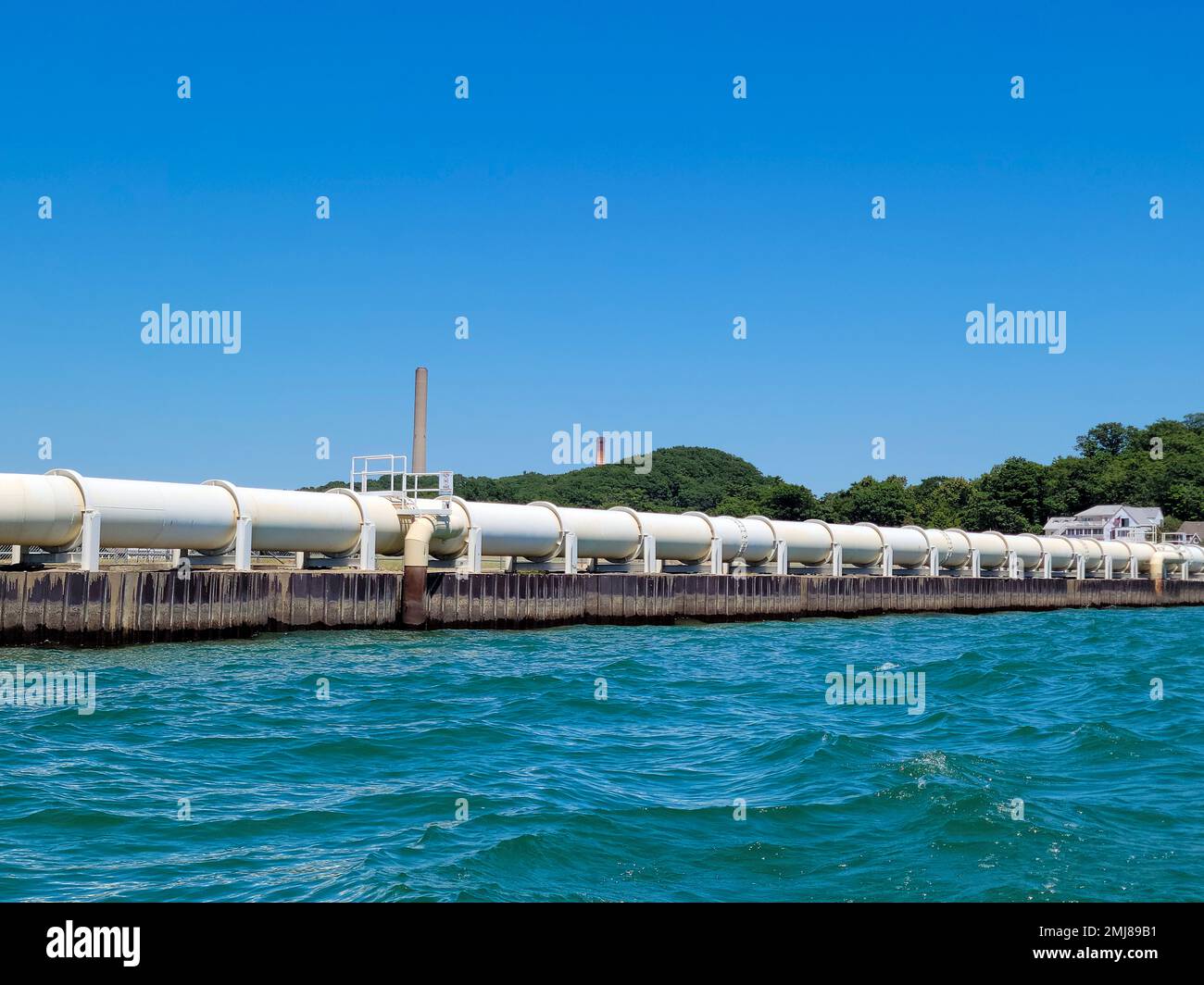 Pipeline industriali bianche sul lago Michigan con cielo blu brillante Foto Stock