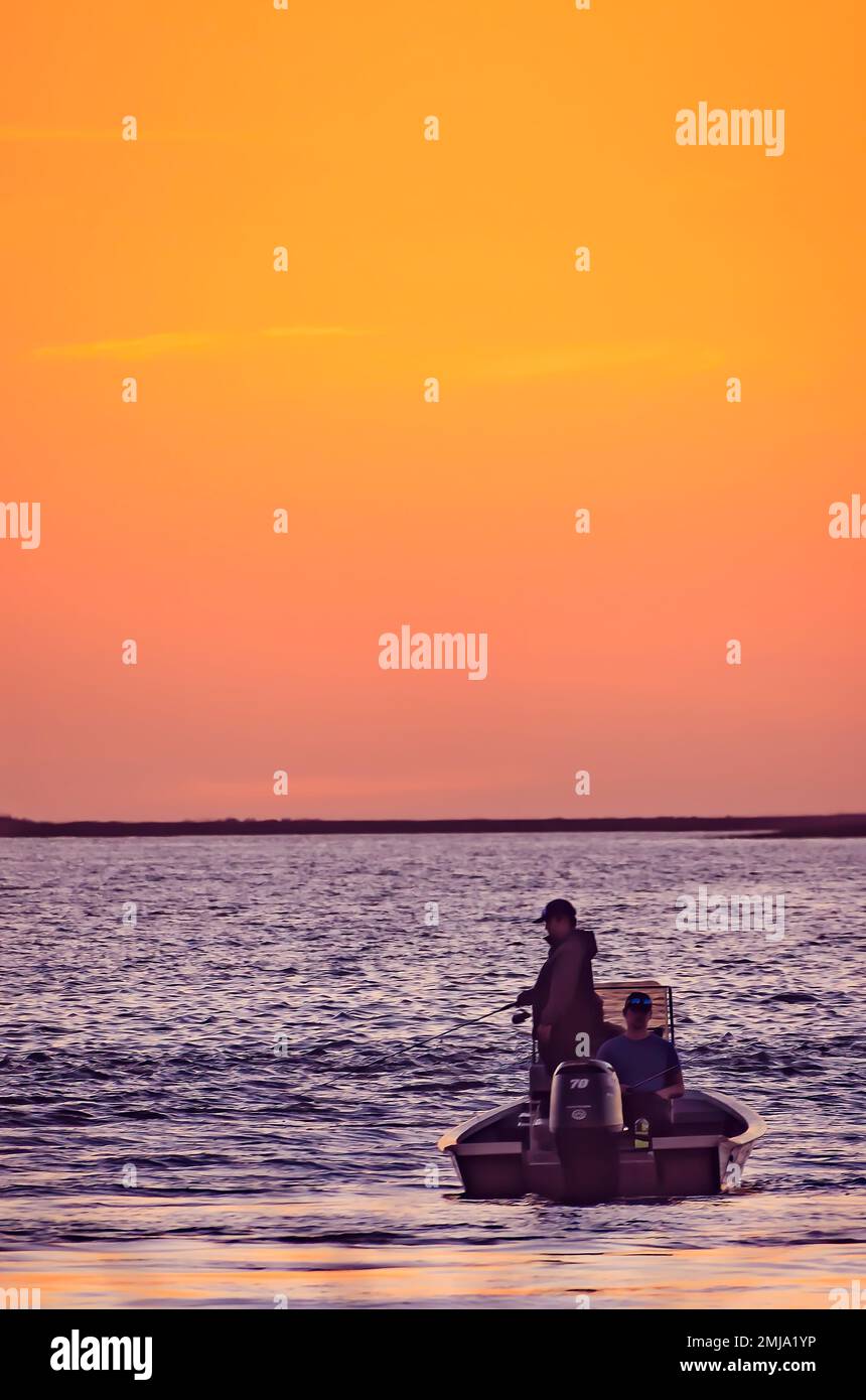 La gente pesca mentre il sole tramonta sopra Heron Bay, 19 gennaio 2023, a Coden, Alabama. Le zone umide di Heron Bay sono gestite attraverso il programma Forever Wild. Foto Stock