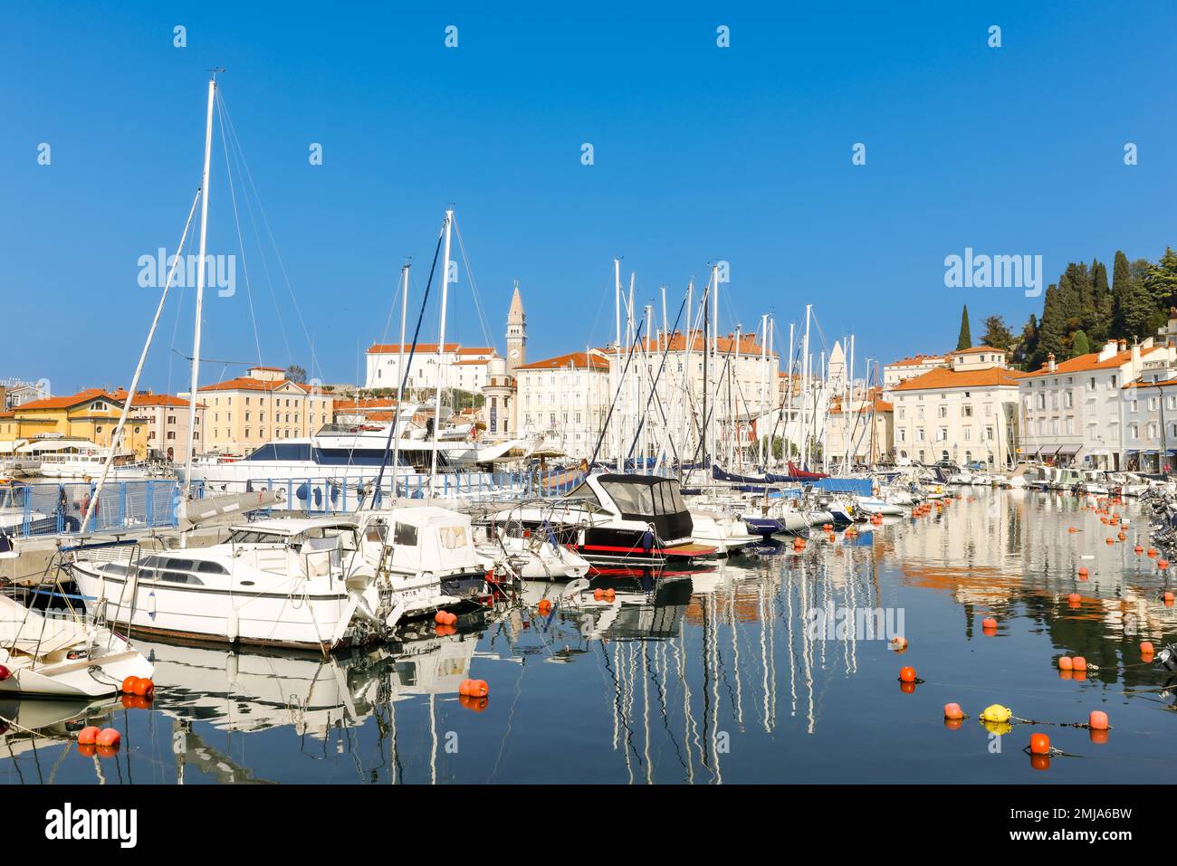 Piran, Slovenia - 14 ottobre 2022: Vista sul porto di Piran Slovenia, vecchie case mediterranee e navi ormeggiate. Skyline con torre dell'orologio sul retro Foto Stock