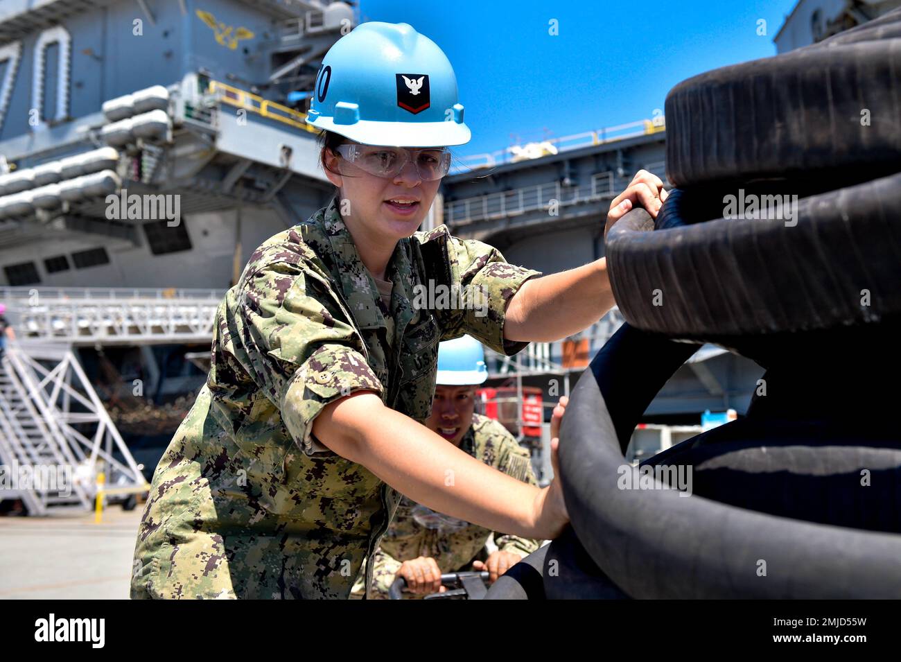 220826-N-EE352-1029 SAN DIEGO (26 agosto 2022) Aviation Boatswain’s Mate (rifornimento) 3rd Class Alexis Mitchell, nativo di Mitchell, Ind., trasporta tubi di carburante lungo il suo piano vicino alla portaerei di classe Nimitz USS Carl Vinson (CVN 70), 26 agosto. Vinson è attualmente pierside nel suo homeport di San Diego. Foto Stock