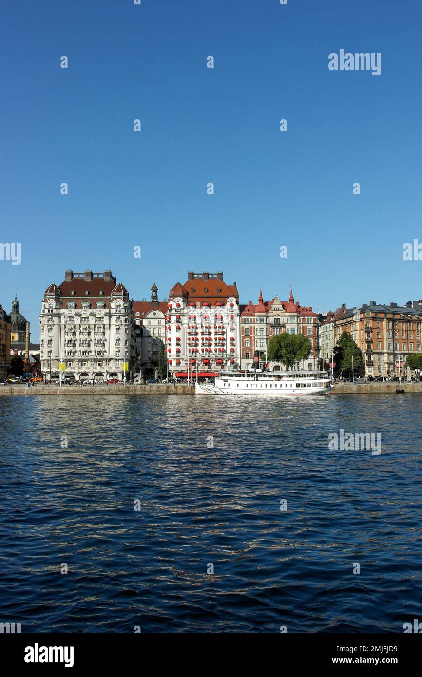 Vista degli edifici lungo il fiume contro il cielo blu chiaro Foto Stock