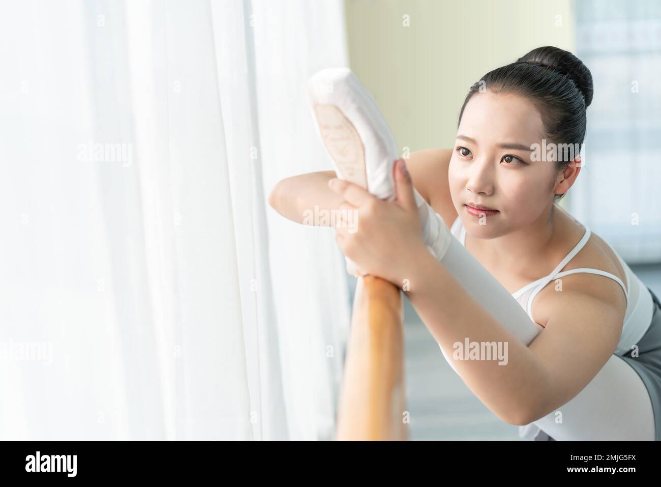 Una giovane donna in pratica balletto studio di danza Foto Stock