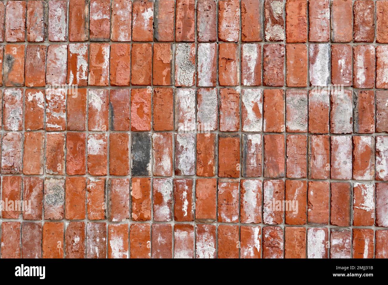 Un primo piano di un muro di mattoni rossi alle intemperie. Foto Stock