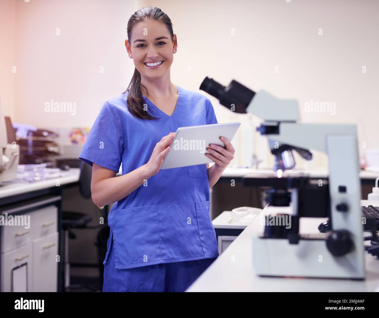 Il mio piccolo e pratico assistente di laboratorio. Ritratto di un giovane scienziato utilizzando una tavoletta digitale mentre lavora in laboratorio. Foto Stock