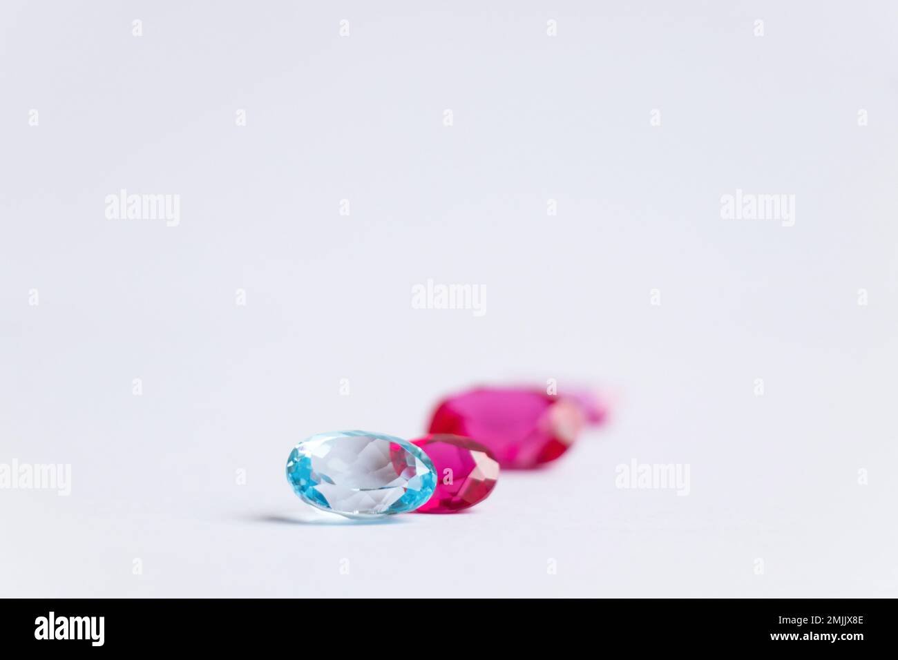 pietre rosa sfaccettate e preziose di varie forme e dimensioni su sfondo bianco Foto Stock