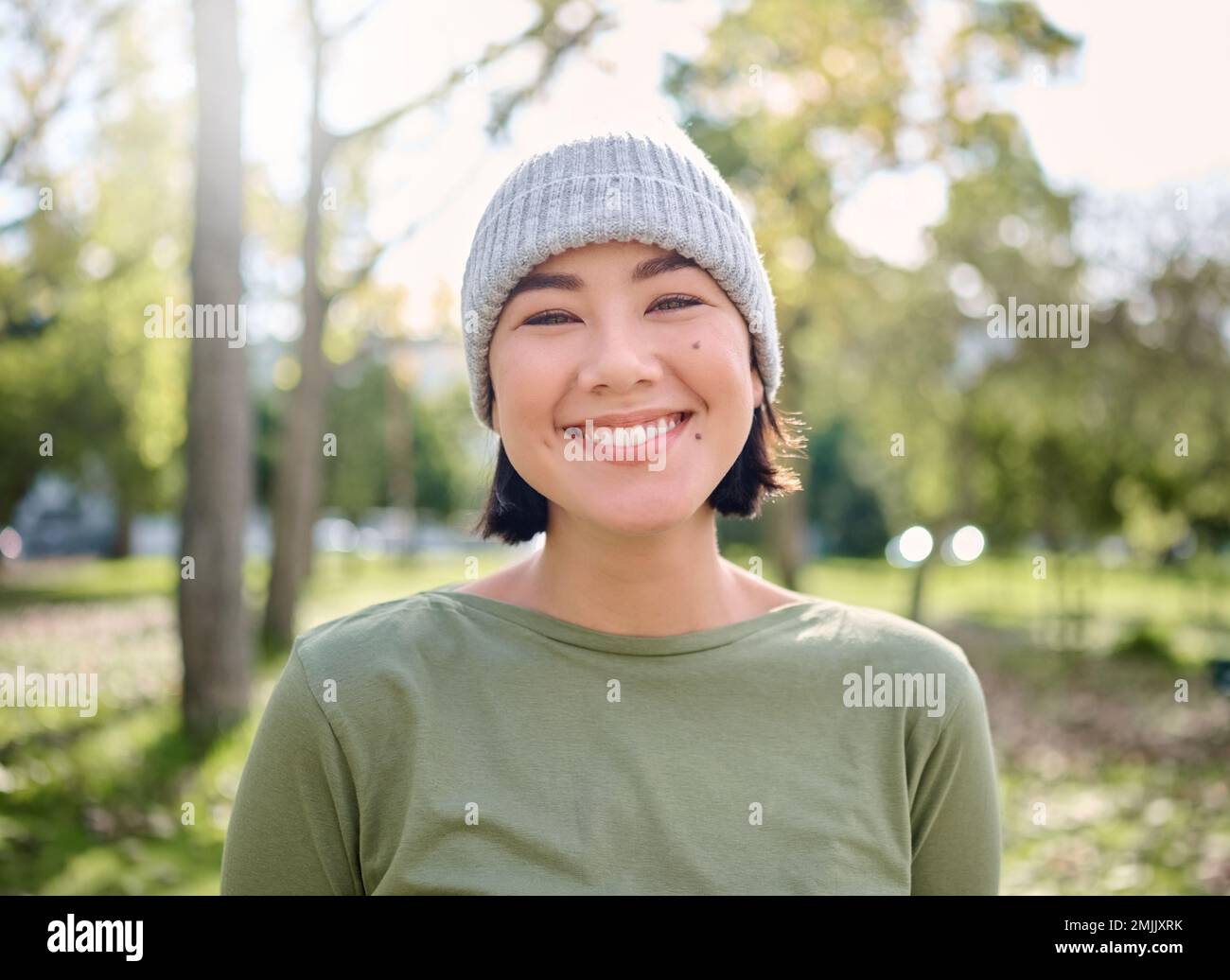 Natura, sorriso e ritratto di donna asiatica in foresta per l'avventura, la libertà e l'escursionismo per il fitness. Benessere, relax e viso di ragazza godendo di aria fresca Foto Stock