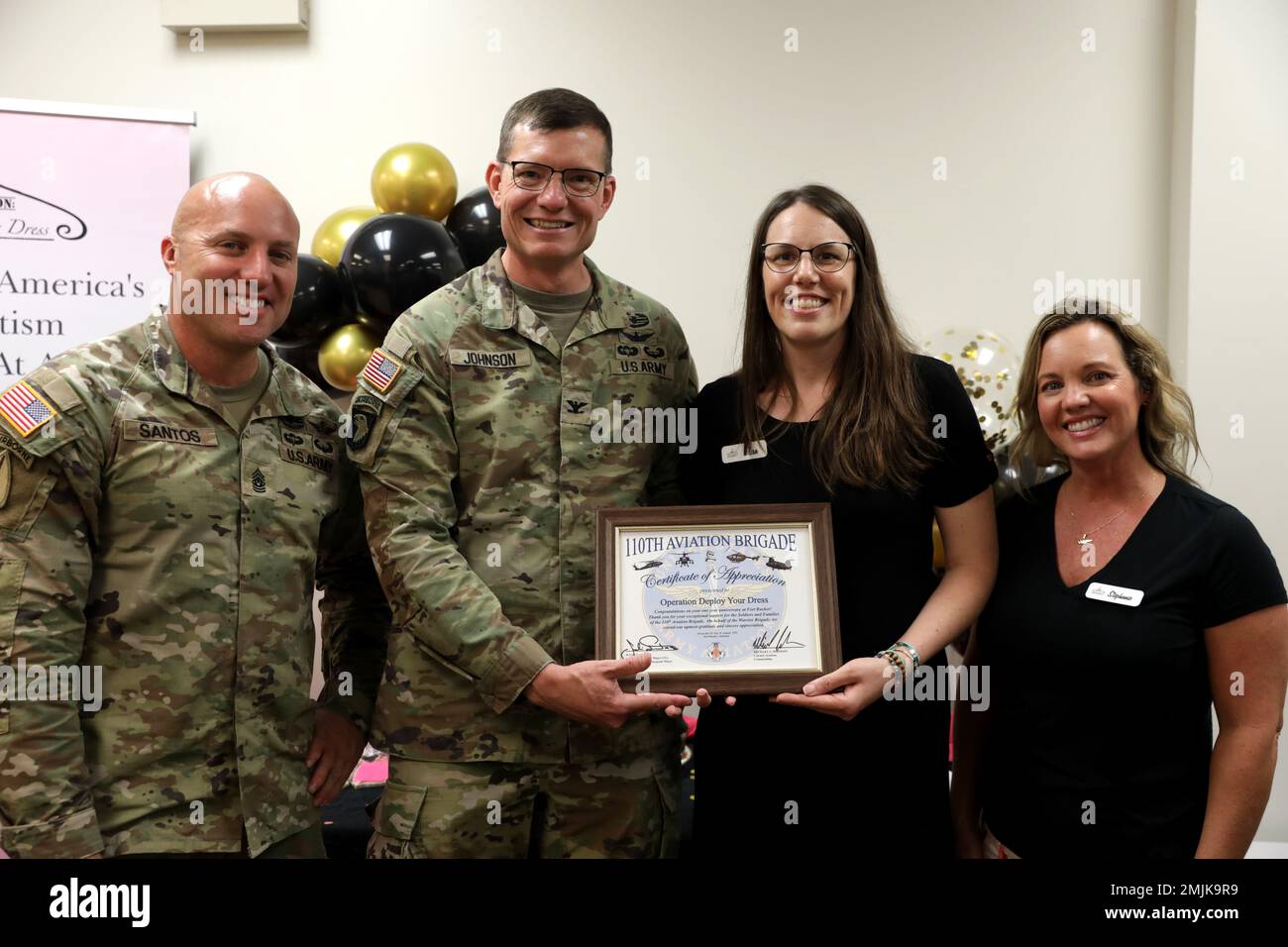 Julio Santos, 110th Aviation Brigade, presenta Elesa Johnson e Stephanie Tucker con un certificato di apprezzamento per il loro sostegno e sforzi alla Brigata Aviazione 110th nel corso dell'ultimo anno in operazione distribuire il vostro abito (ODYD,), Fort Rucker, Alabama, 31 agosto 2022. L'idea di ODYD si è sviluppata in una grande organizzazione, gestita interamente da volontari. Foto Stock