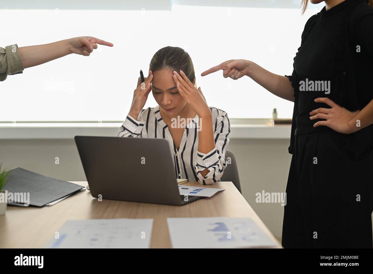 Una giovane dipendente frustrato che riceve ingiusto rimprovero, soffre di un cattivo atteggiamento sul lavoro. Concetto di stress sul lavoro Foto Stock