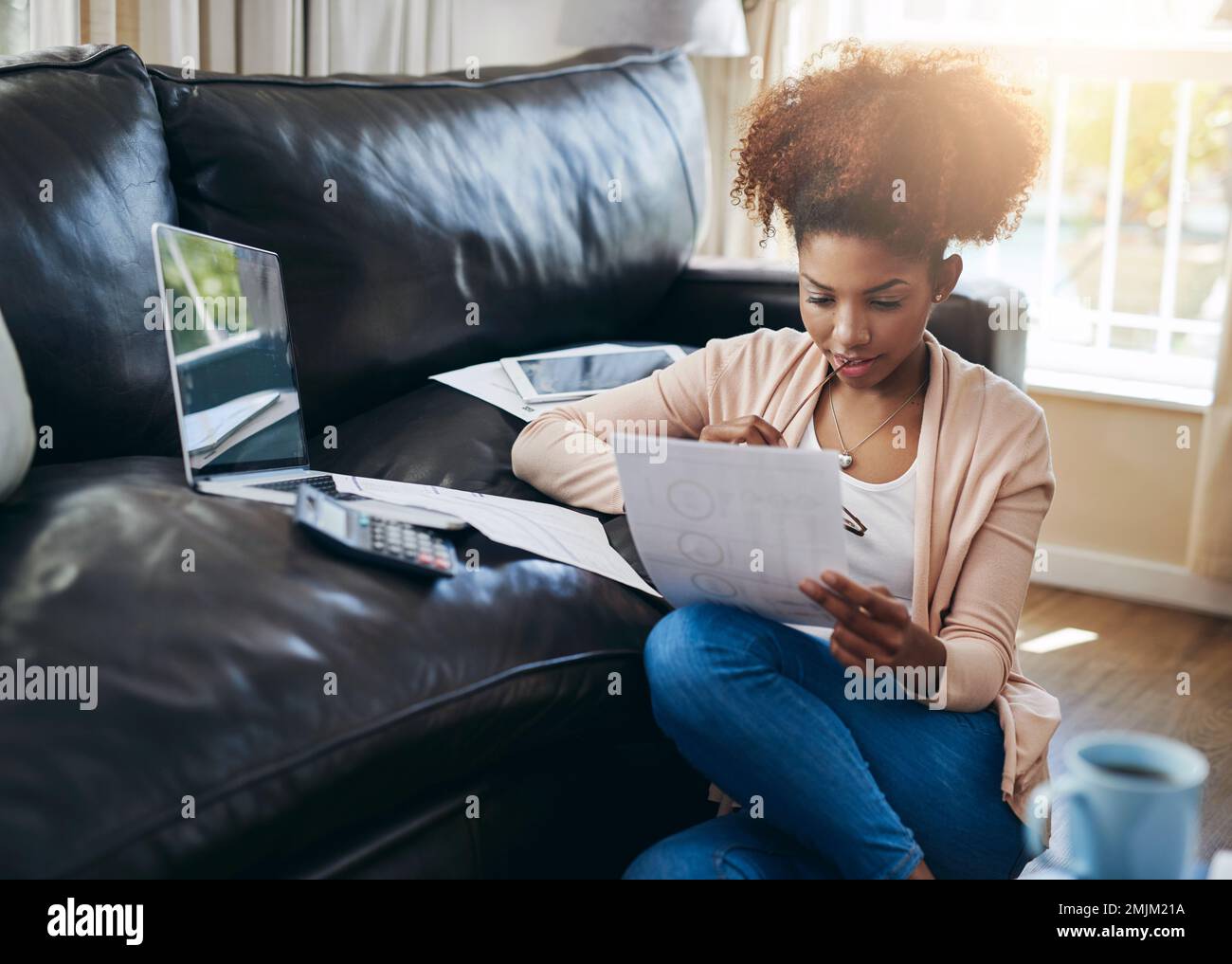 Verifica del suo stato finanziario. una giovane donna che passa attraverso il suo lavoro di ufficio a casa. Foto Stock