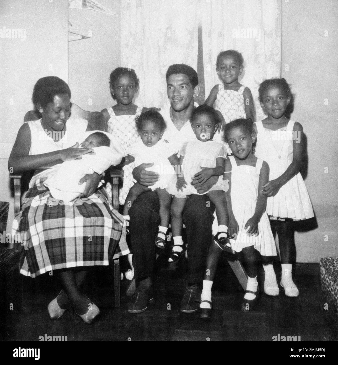 Footballer Garrincha, center, poses with his family, from left: wife Nair, holding baby Terezinha; Tereza, 10, Denise, 4, Maria Cecilia, 3, Edenir, 9, Juraciara, 5, Marinete, 7, at their home in Pau Grande, Brazil, 1963. (AP Photo) Foto Stock