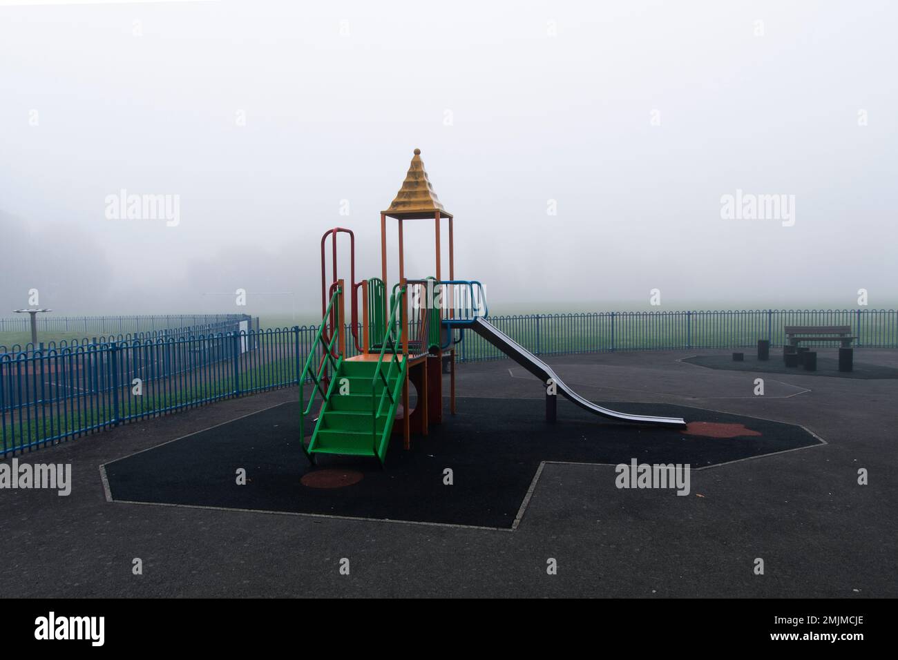 Attrezzature per bambini in un parco locale nella nebbia Foto Stock