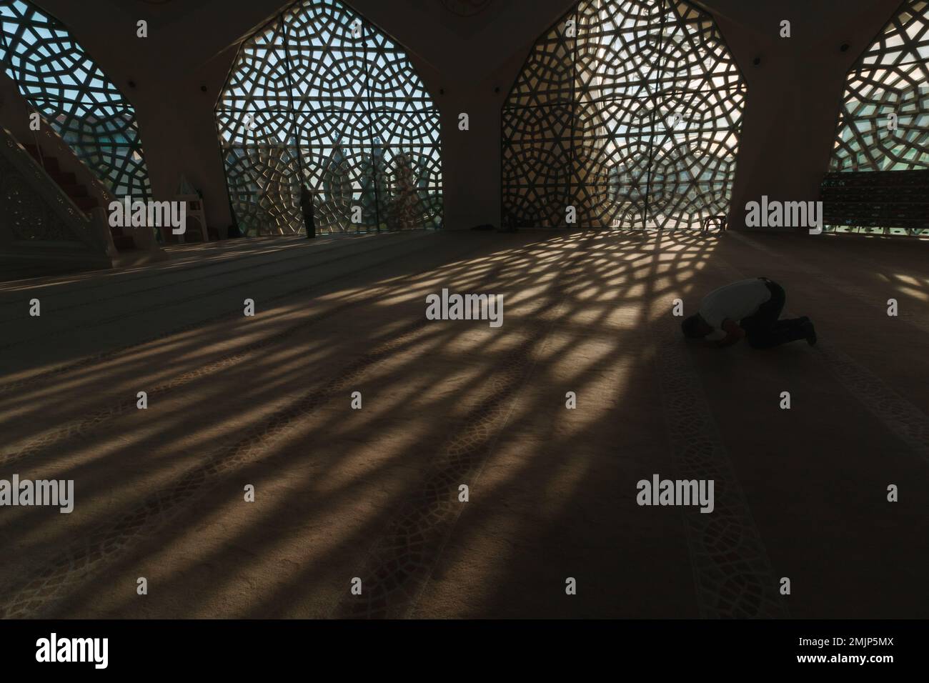 Foto di sfondo Ramadan o islamica. Uomo musulmano che prega nella moschea. Ombre di finestre sul terreno. Istanbul Turkiye - 9.26.2022 Foto Stock