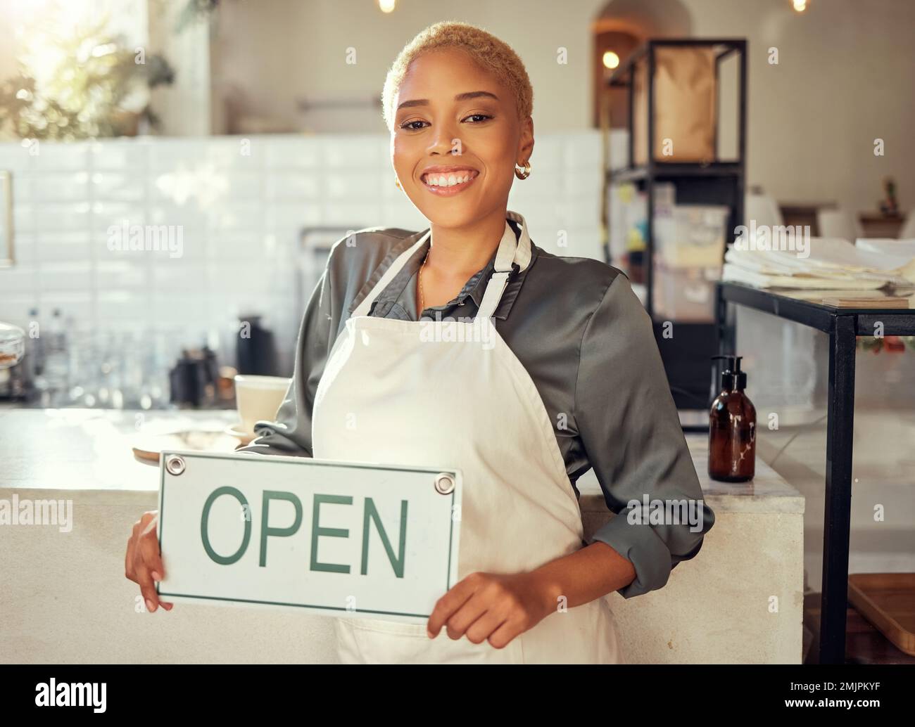 Open sign, business e ritratto nero donna in startup caffè, ristorante o bar con un sorriso per il successo. Cameriera, manager o persona mano Foto Stock