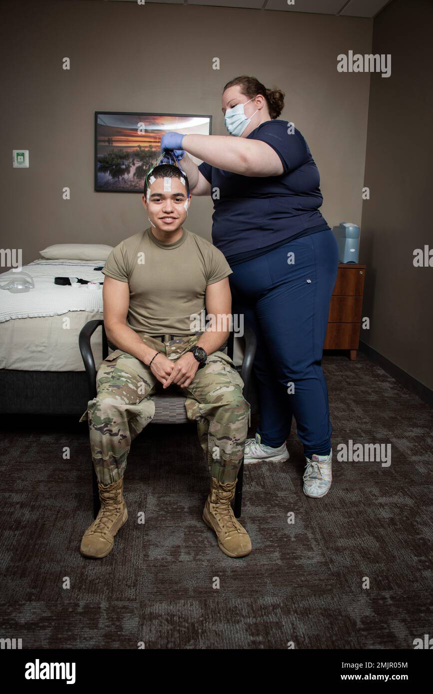 Sarah Hawkins, tecnico polisomnografico registrato, prepara il paziente Airman 1st Classe Austin Starks, 59th Medical Specialty Squadron Health Service Management journeyman, per uno studio sul sonno presso il San Antonio Market Sleep Disorders Center presso il Wilford Hall Ambulatory Surgical Center, Joint base San Antonio-Lackland, Texas, 31 agosto 2022. Un team di ricercatori militari e civili ha identificato un nuovo disturbo del sonno che sta sconvolgendo la vita dei sopravvissuti ai traumi per decenni, se non per secoli. Anche se ci sono stati studi correlati, questo è stato il più grande fino ad oggi e identifica trauma asso Foto Stock